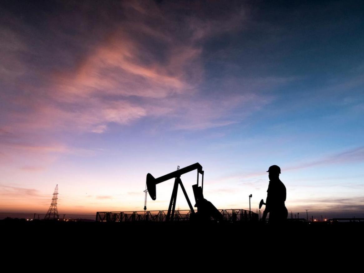 On the job, petroleum engineering with a pink and blue sky. 