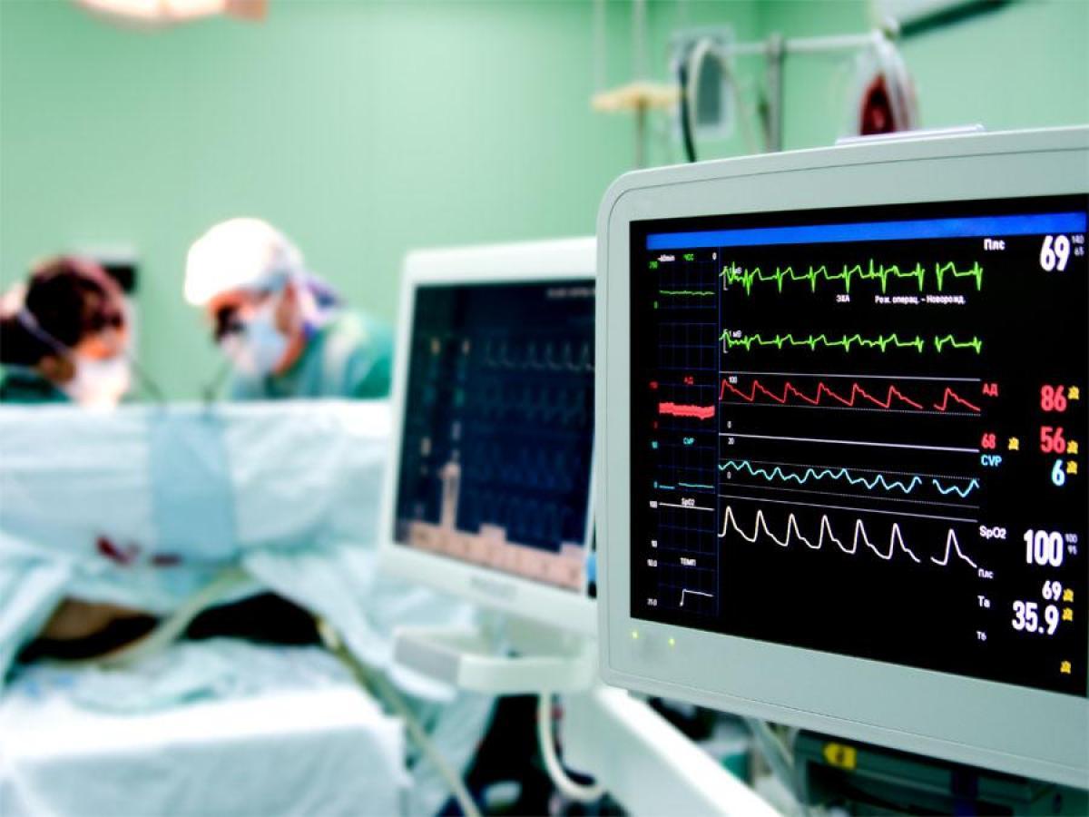 Two screens in theatre with medical signals showing