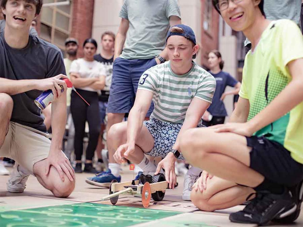 3 male students participating in the design and build competition during O'Week