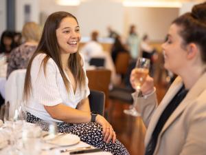 lady smiling at her friend who is drinking wine