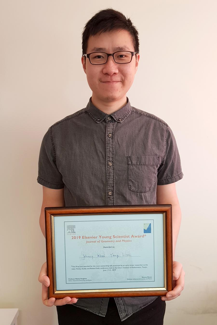PhD student, Mr Johnny Lim with his award