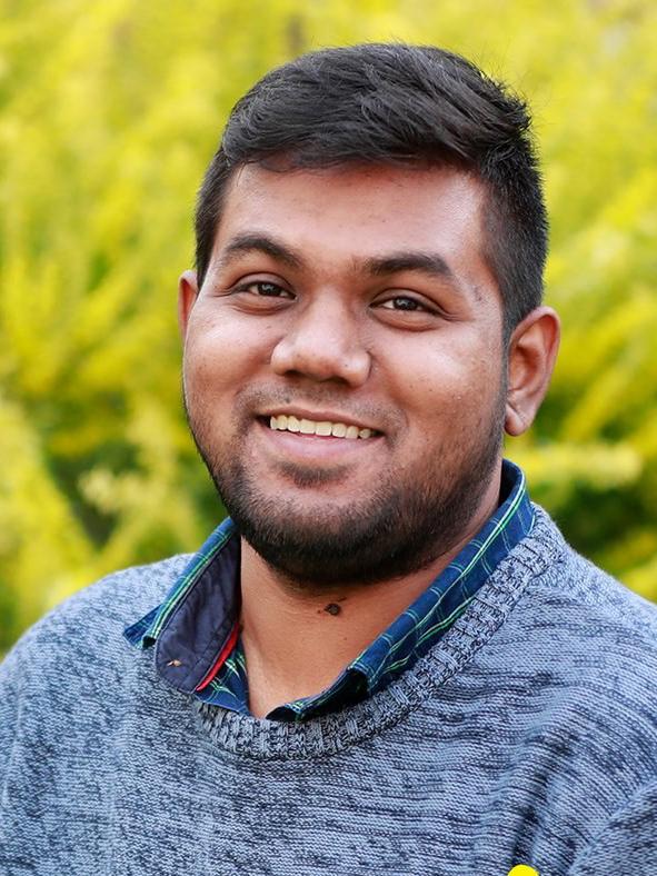 Abdul Rahim Mohammad smiling in front of a green leafy background