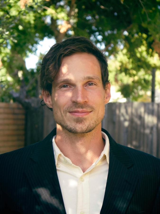 Richard Pinter stranding in front of a green leafy tree