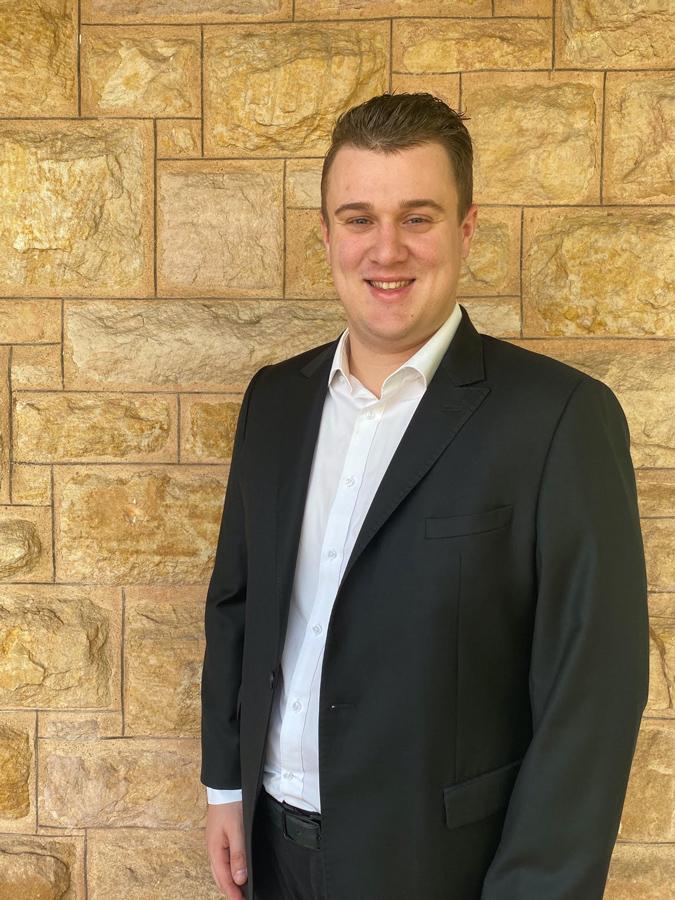Thomas Lancione standing in front of a brick facade