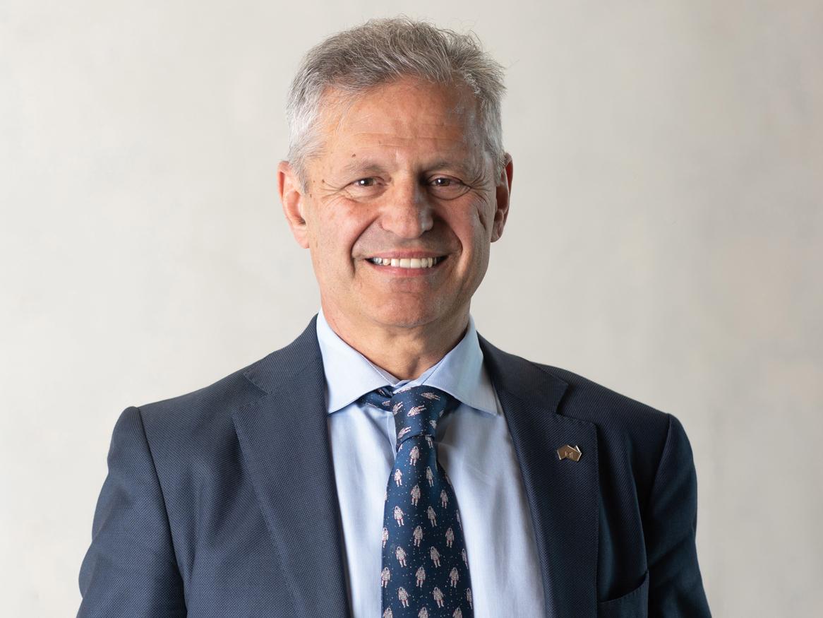 Andy Koronios, CEO of SmartSat smiling in a blue suit