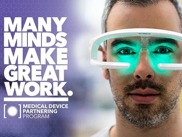 Many minds make great work - medical device partnering program. Picture shows a man with a glasses device on his face.