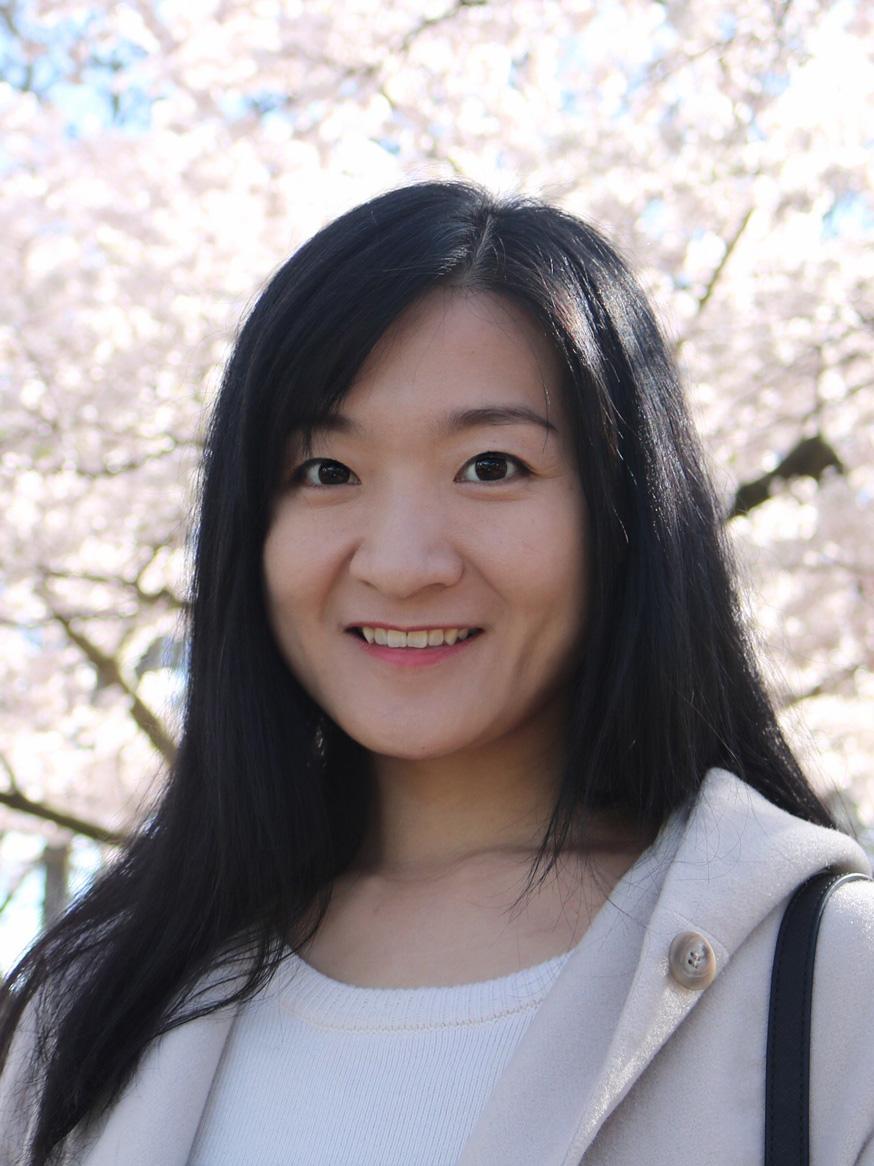 Yujie Chen smiling with cherry blossoms in the background