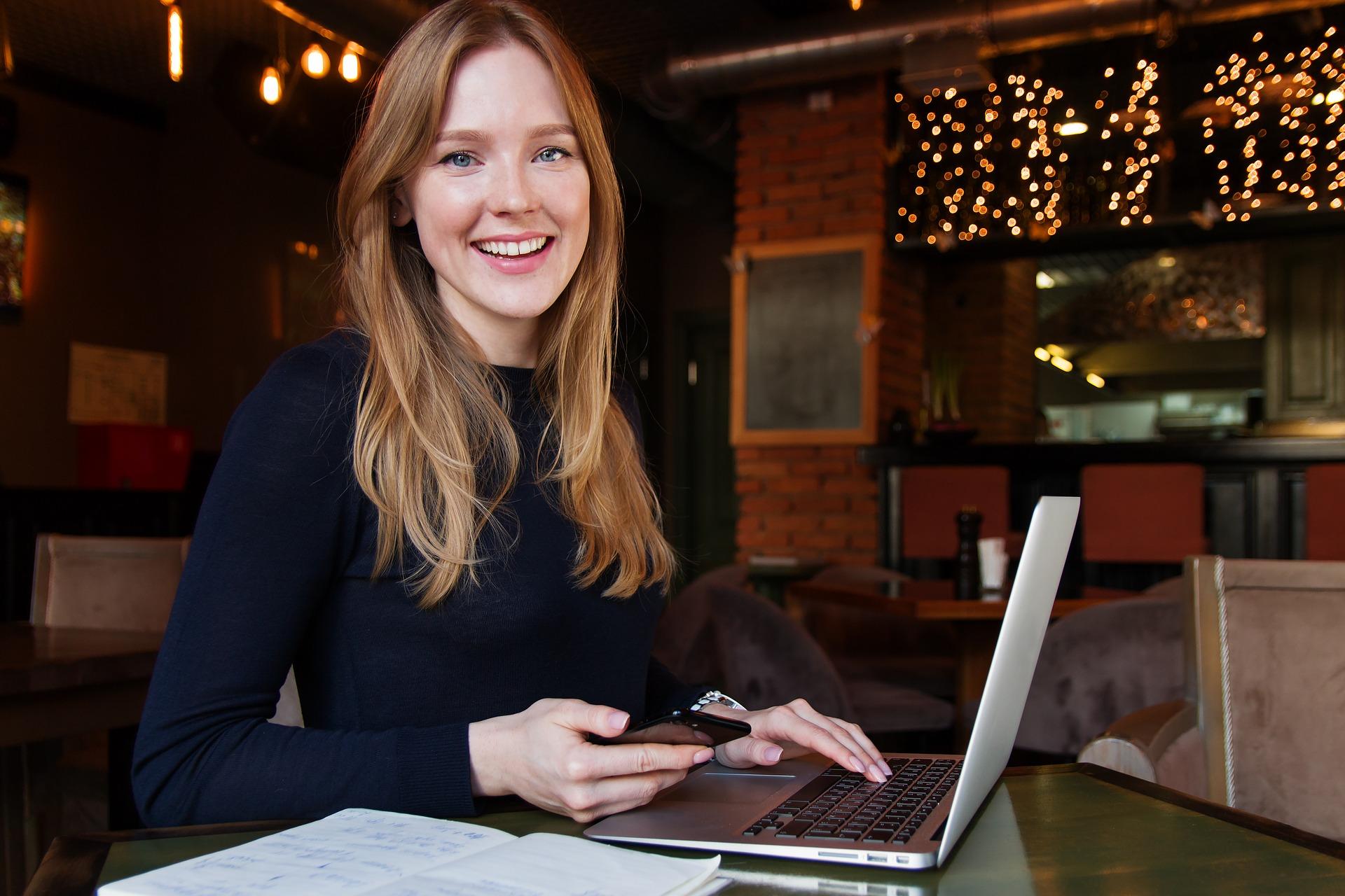 Young business woman sitting with a laptop, phone and notebook