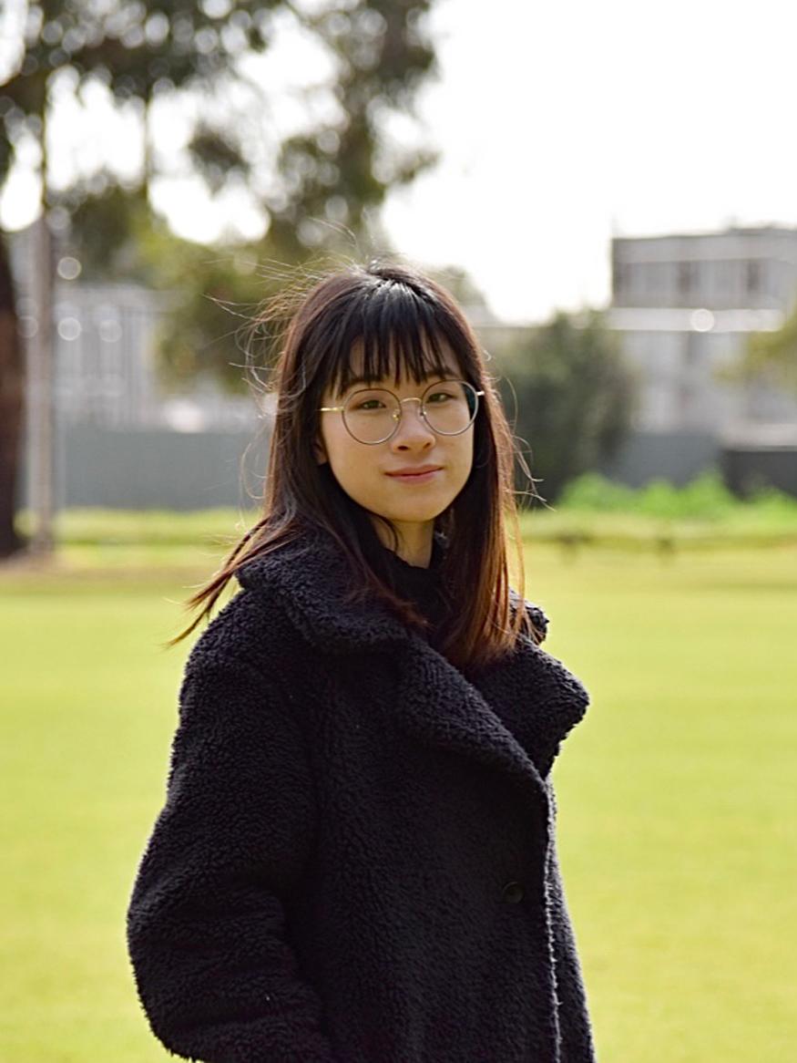 Photo of Fei Yang Huang outside with green grass and a tree in the background