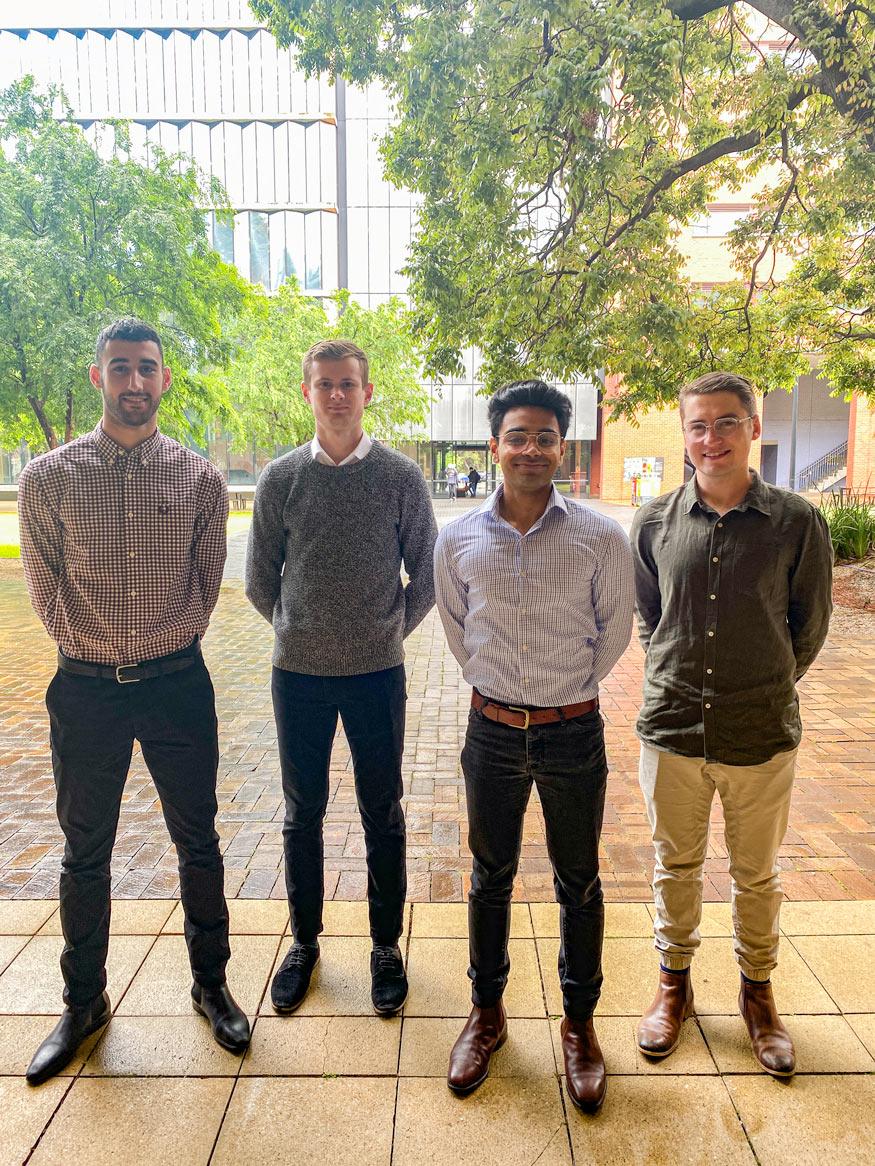 image of four men in shirts standing outside