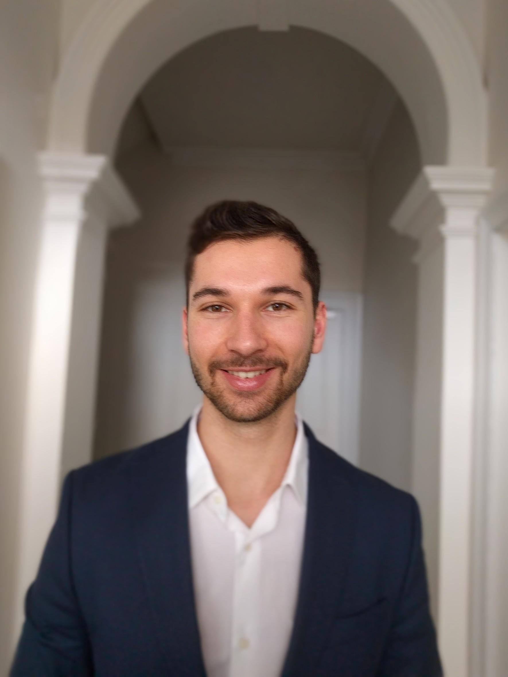 Professor Vasileff in dark blazer and white shirt looking at camera