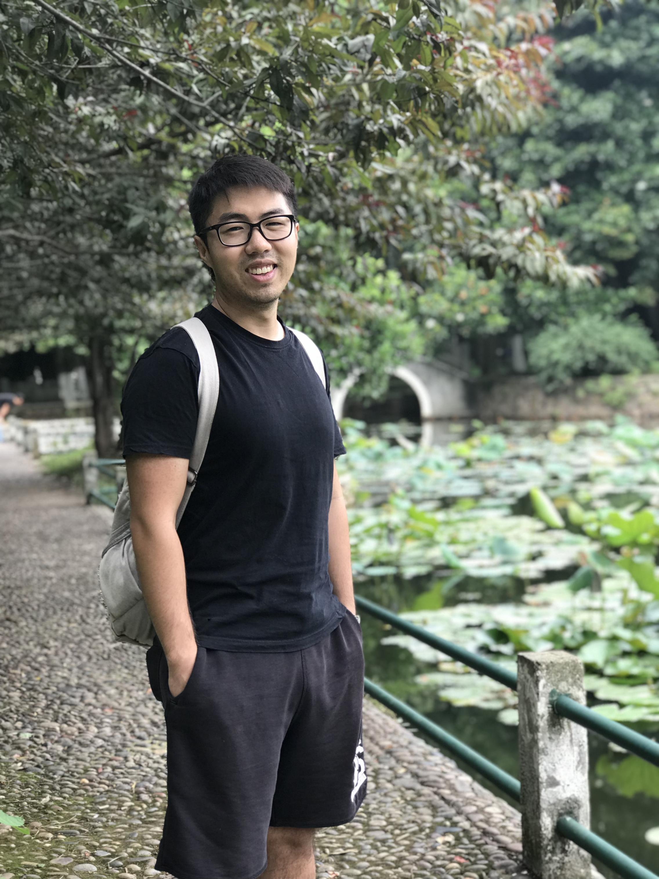 Man in black t-shirt and shorts nearby a lake