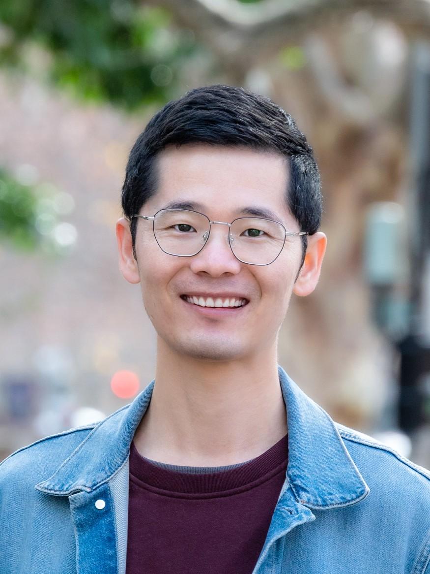Xiaoguang Duan facing camera, wearing blue shirt and red t-shirt