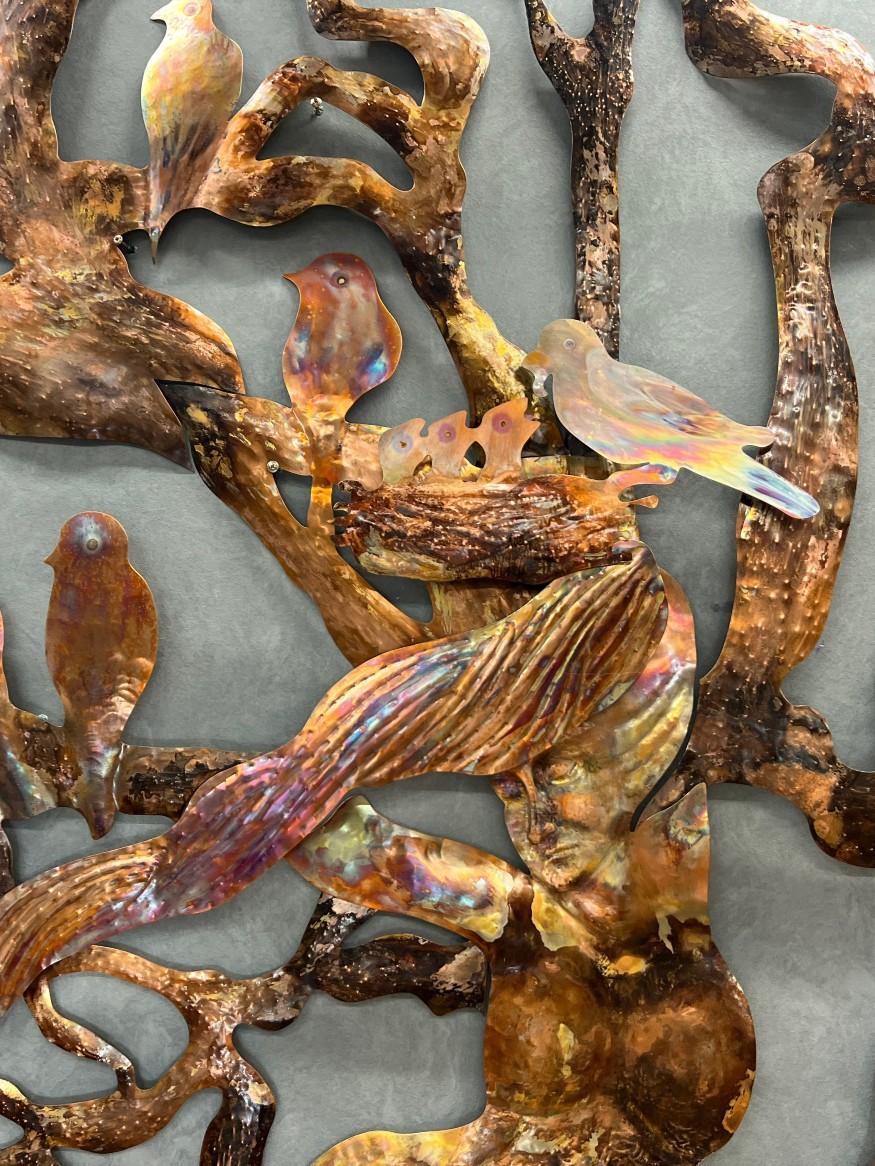 Close up of metal birds sitting in metal branches