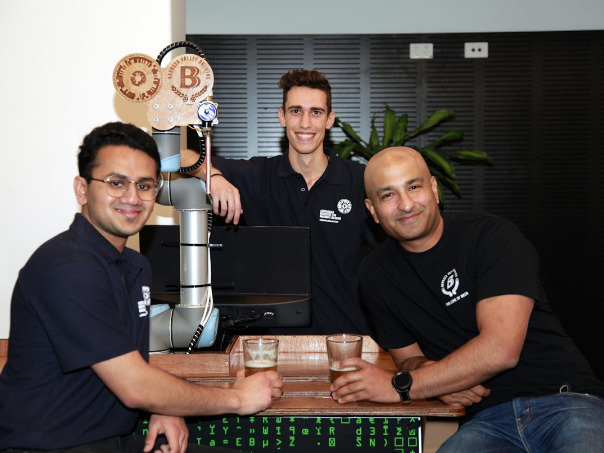 three men wearing navy tshirts holding beer