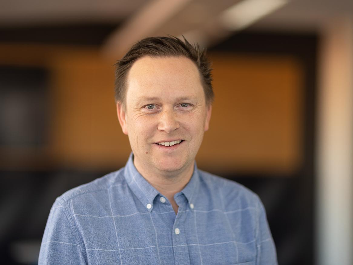 image of simon holford smiling wearing a blue shirt