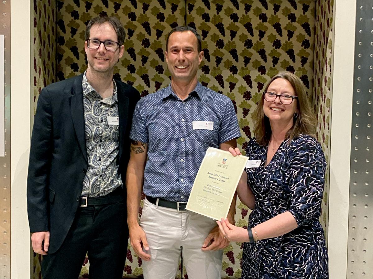 School of Biological Sciences’ researcher Bastien Llamas receives the Order of Merit in the mid-career award category from Professors Martin White and Laura Parry.
