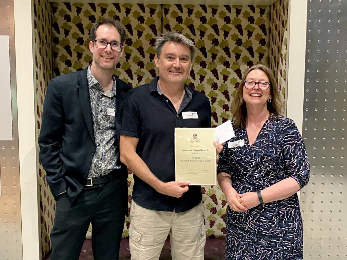 Professor Gavin Rowell from the School of Physical Sciences receives the Research Leadership Award from Professor Martin White and Laura Parry.