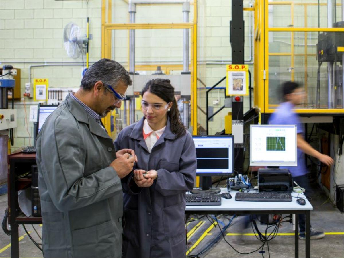 Staff member working with student in the engineering lab