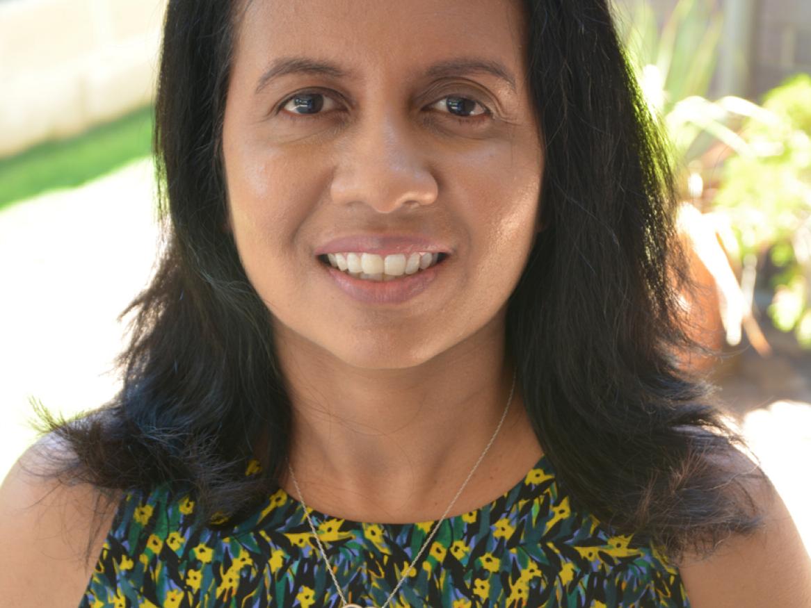 Thushari Atapattu from the School of Computer Science wears a green flower top and is smiling.
