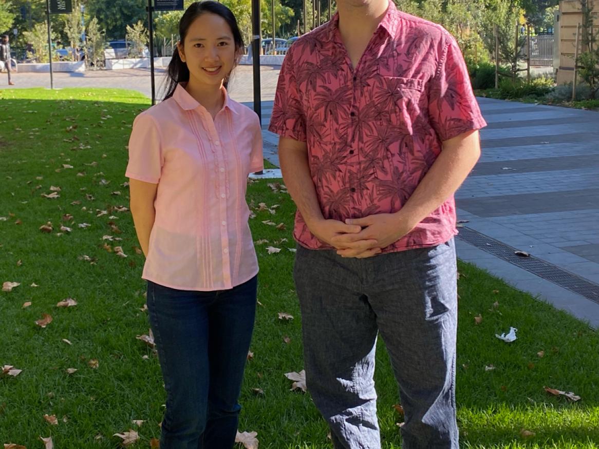 Chuengsatiansup and Wagner standing on the University of Adelaide's lawn with "making history" in the background