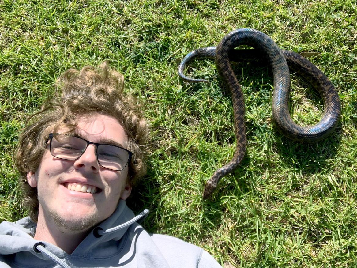 University of Adelaide animal behaviour student Harry Kent with Lizzie the pet spotted python (Antaresia maculosa). Image by Kenty's Wildlife.