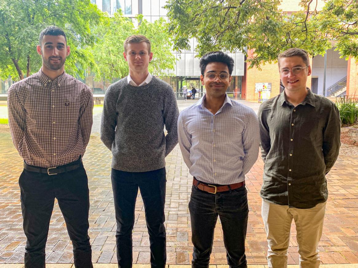 image of four men in shirts standing outside