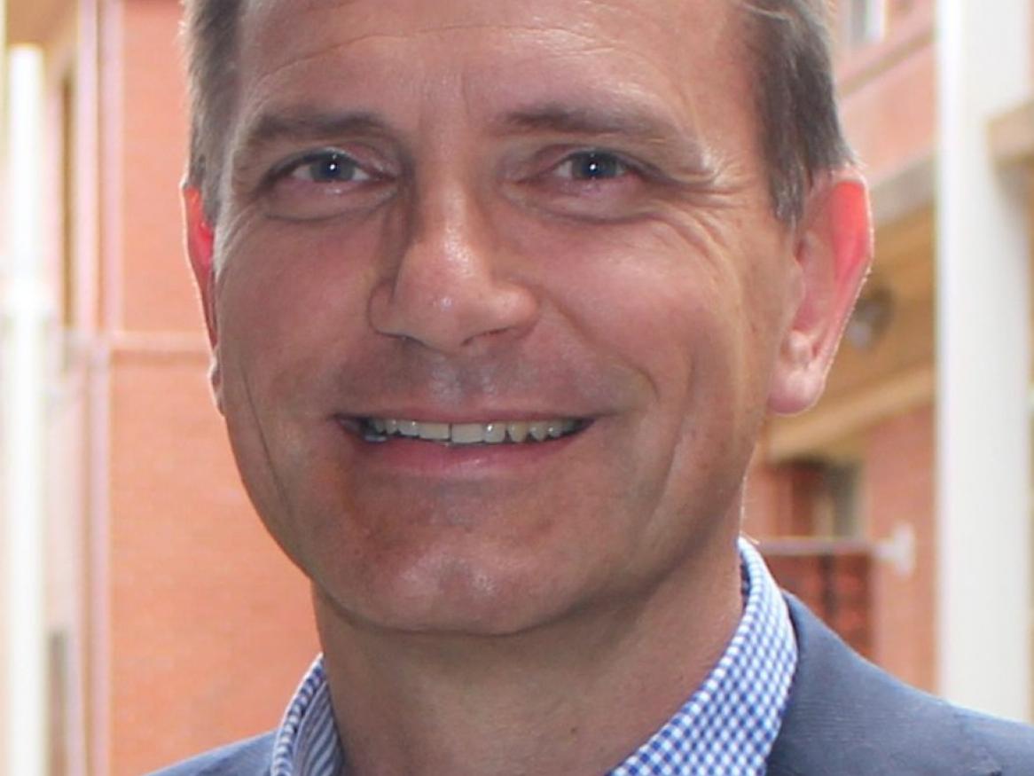Man in blue and white shirt smiling at camera