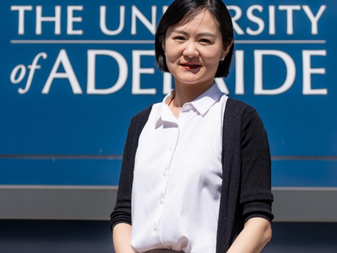 Woman in white shirt and dark cardigan facing the camera