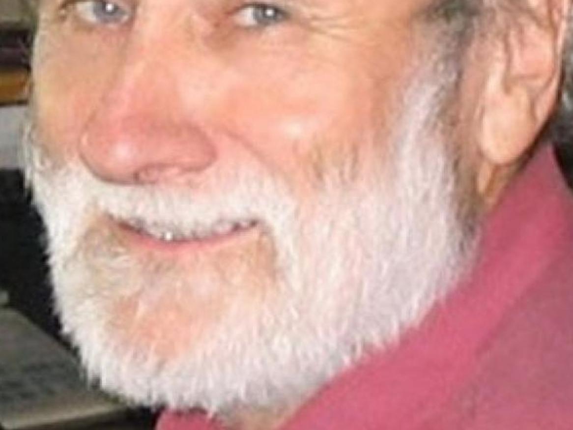 Man with White Beard and Pink Shirt looking at camera