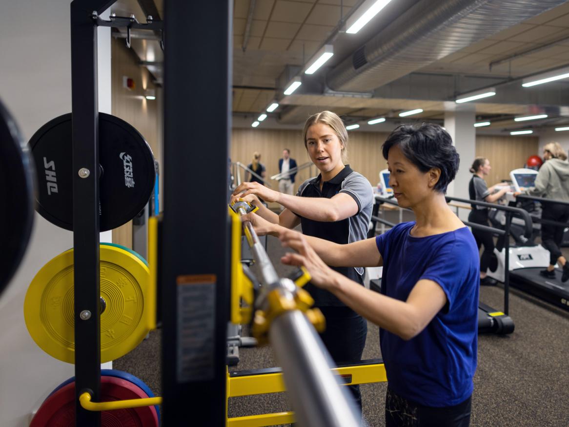 Woman in gymnasium with allied health professional